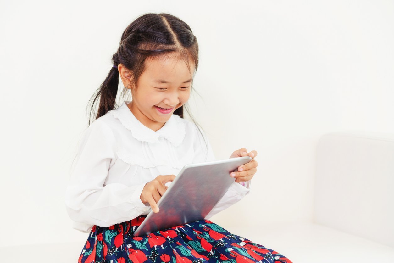 Little kid on white background with tablet